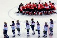 Canadian women pose for championship photo after a stunning comeback as the United States team skates away.