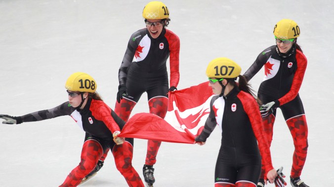 Short track team skates with the flag following the final result, a silver for Canada as China was disqualified.