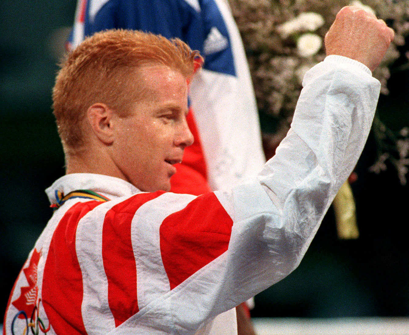 Mark Leduc raises his arm after being awarded his Olympic boxing silver medal. 