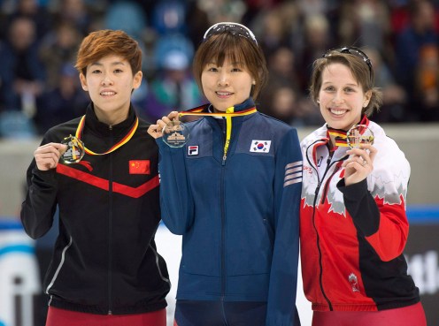 Winner Kim Alang of South Korea, center, celebrates with second placed Fan Kexin of China, left, and third placed Marianne St-Gelais of Canada during the medal ceremony after the women's 1,000 meter final race at the World Cup short track speed skating championship in Dresden, Germany, Saturday, Feb. 7, 2015. (AP Photo/Jens Meyer)