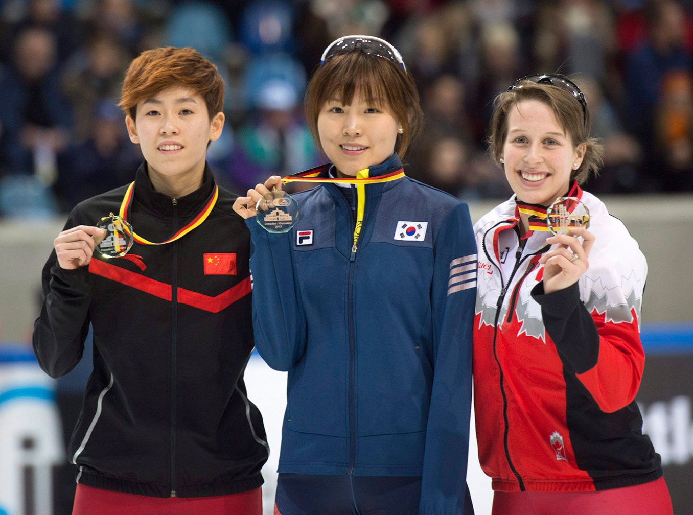 st-gelais-1- Winner Kim Alang of South Korea, center, celebrates with second placed Fan Kexin of China, left, and third placed Marianne St-Gelais of Canada during the medal ceremony after the women's 1,000 meter final race at the World Cup short track speed skating championship in Dresden, Germany, Saturday, Feb. 7, 2015. (AP Photo/Jens Meyer)