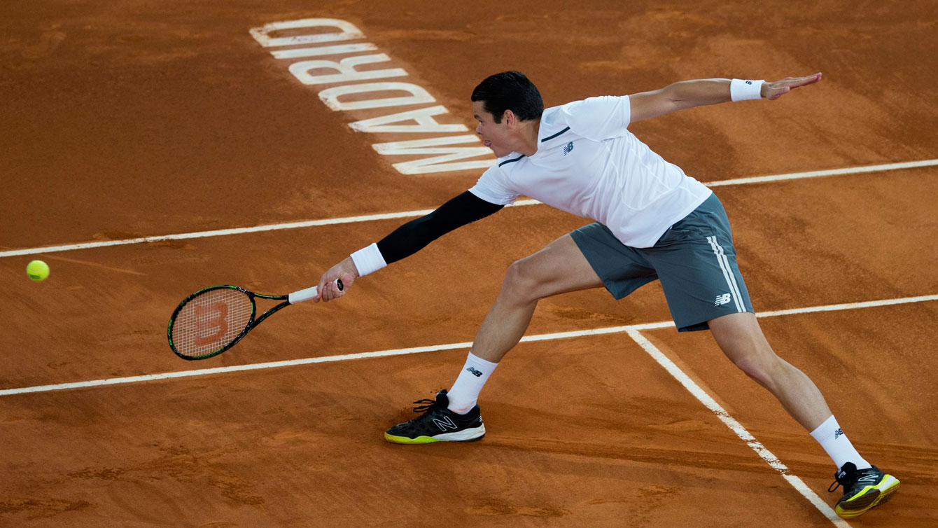 Milos Raonic reaches to return a shot against Andy Murray on May 8, 2015 at Madrid Masters. 