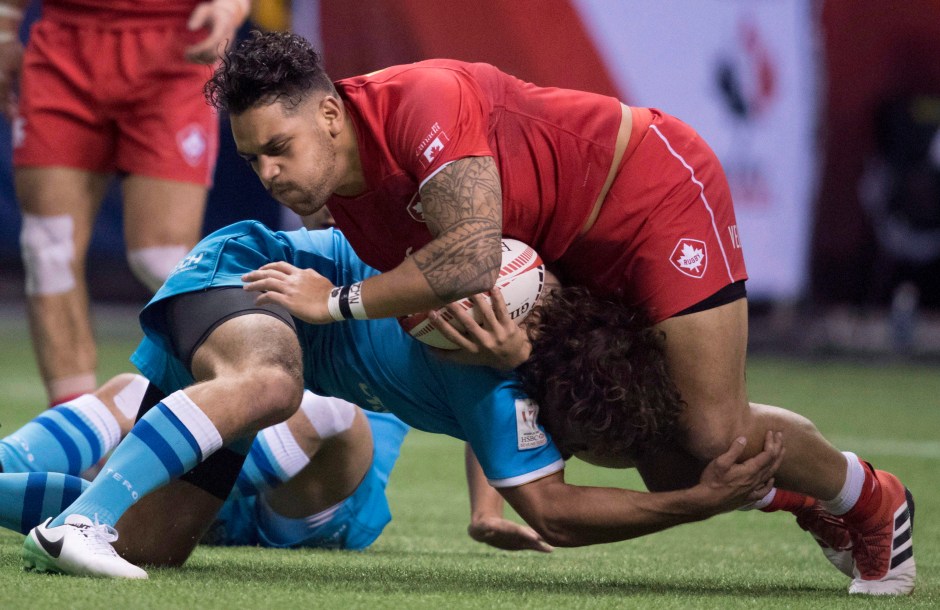 Mike Fuailefau of Canada tries to get past Diego Ardao of Uruguay during the World Rugby Seven Series at B.C. Place