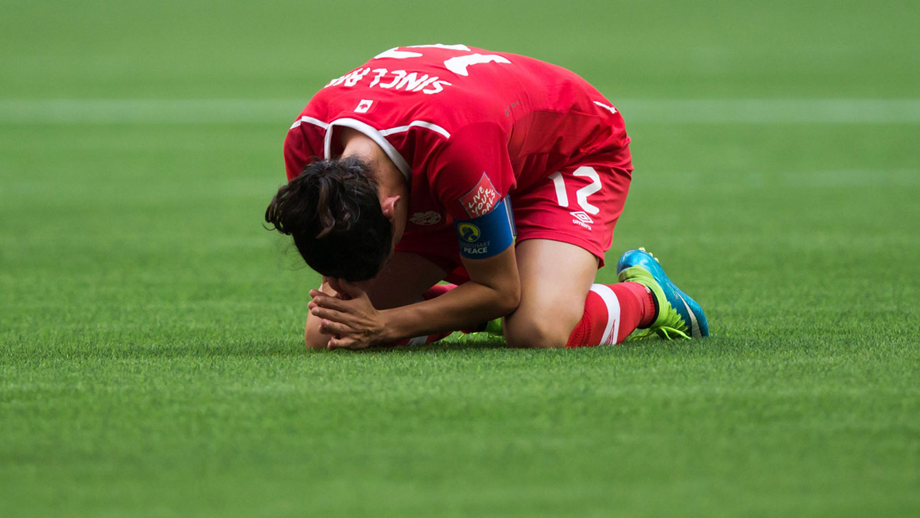 A dejected Christine Sinclair goes to ground at the final whistle as Canada loses 2-0 to England at the FIFA Women's World Cup on June 27, 2015. 