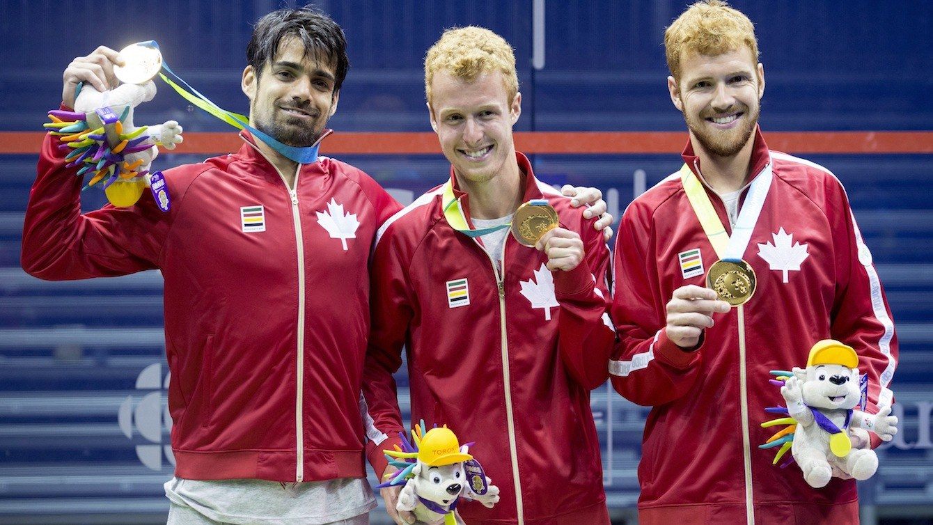 Canadian men's squash team, from left to right, Shawn Delierre, Andrew Schnell, and Graeme Schnell pose with their gold medal in men's team squash at the 2015 Pan Am Games.