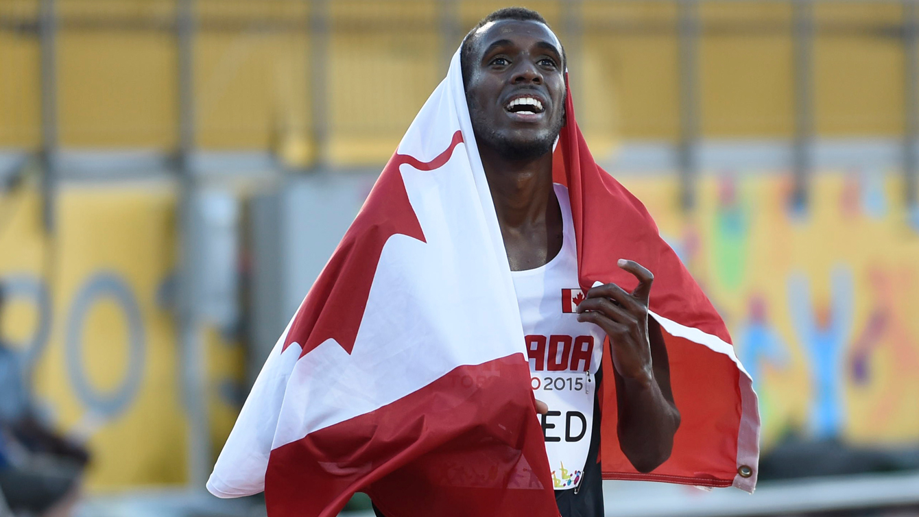 Mo Ahmed wraps himself in the maple leaf after winning the men's 10,000m at the Pan Am Games on July 21, 2015.