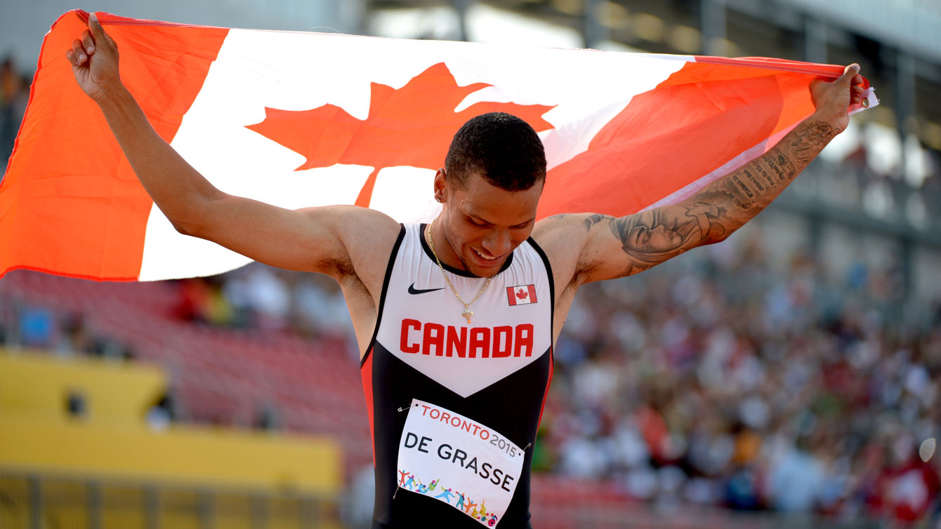 Andre De Grasse with the Canadian flag after winning the 200m Pan Am Games title on July 24, 2015 in Toronto.
