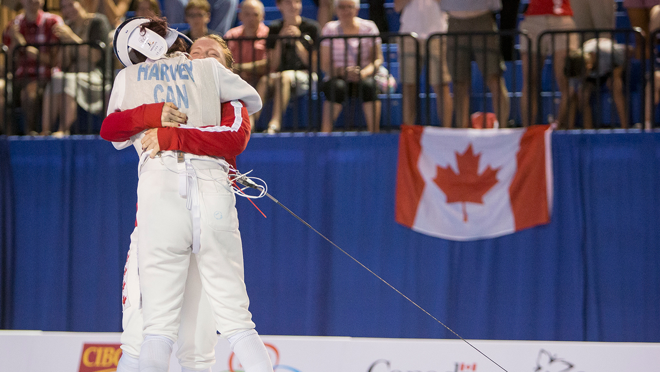 Teammates Kelleigh Ryan (red jacket) and Eleanor Harvey celebrate winning against the United States in the Team Women's Foil gold medal fencing match at the Pan American Games on July 25, 2015.