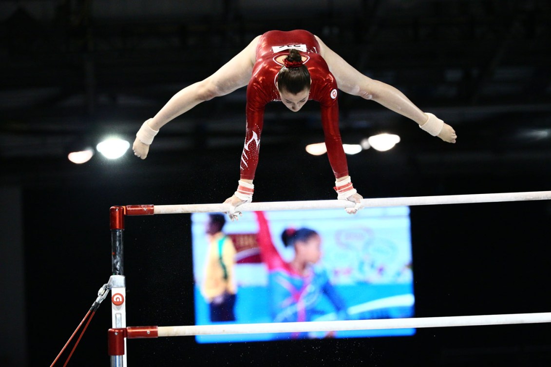Victoria Woo competes on the uneven bars. (Photo: John Fernandez)