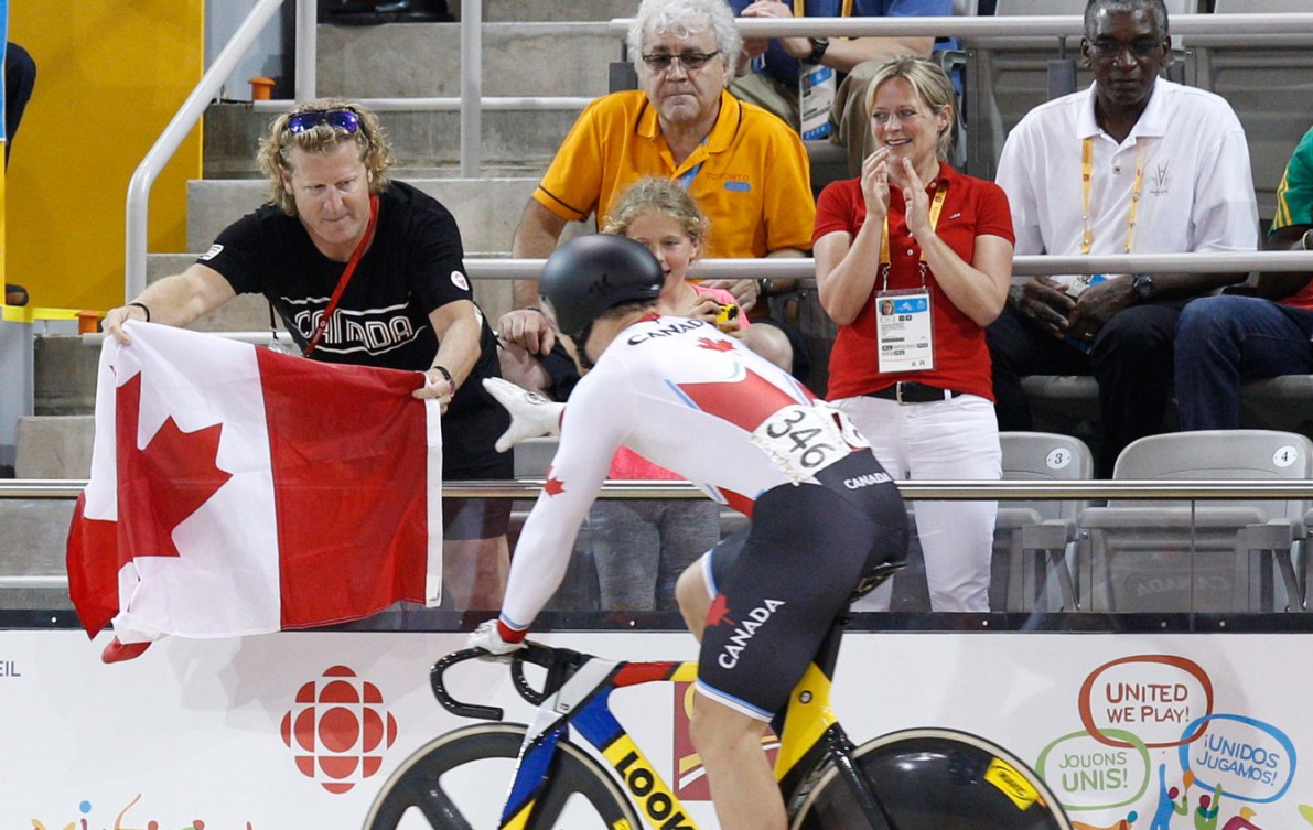 Harnett (far left) gives Hugo Barrette a Canadian flag to celebrate his gold medal.