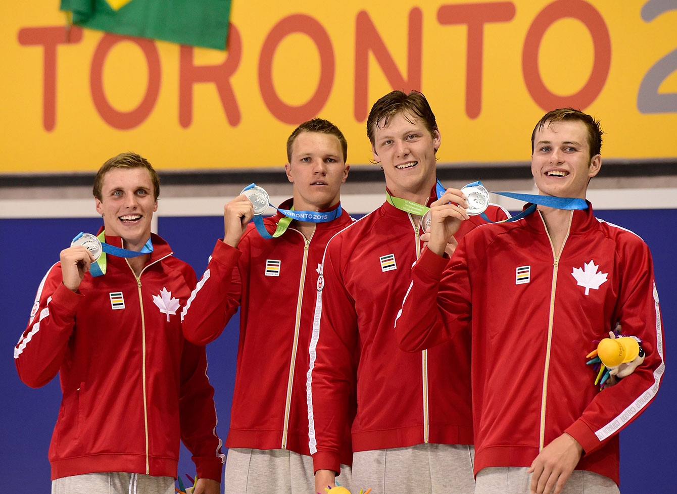 Canadian swimmers Santo Condorelli, left to right, Karl Krug, Evan Van Moerkerke and Yuri Kisil smile as they hold their medals after a second place finish in the men's 4x100 freestyle at TO2015.