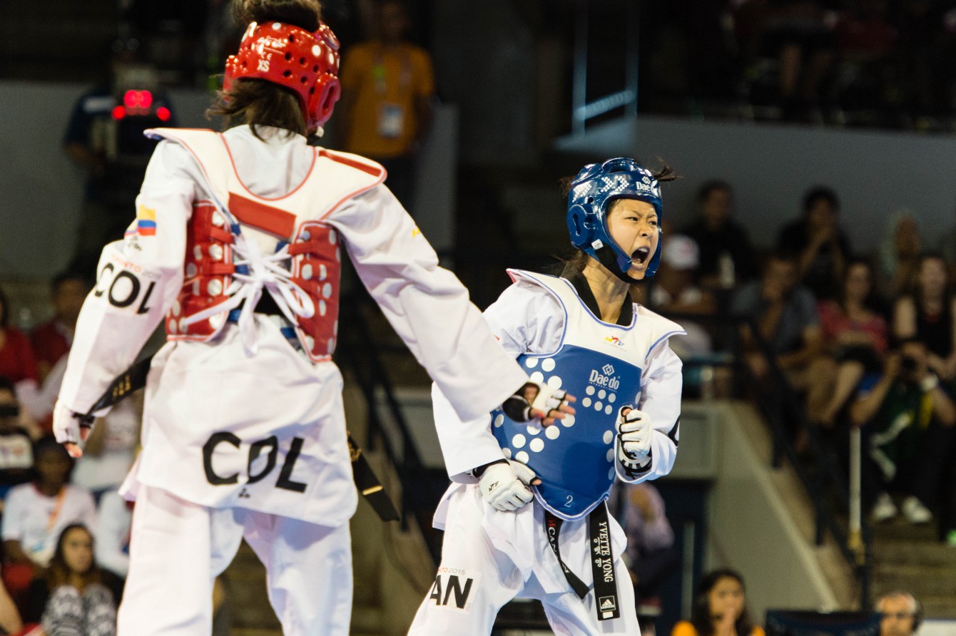 Yvette Yong (blue) in women's taekwondo quarterfinals (COC Photo by Winston Chow)