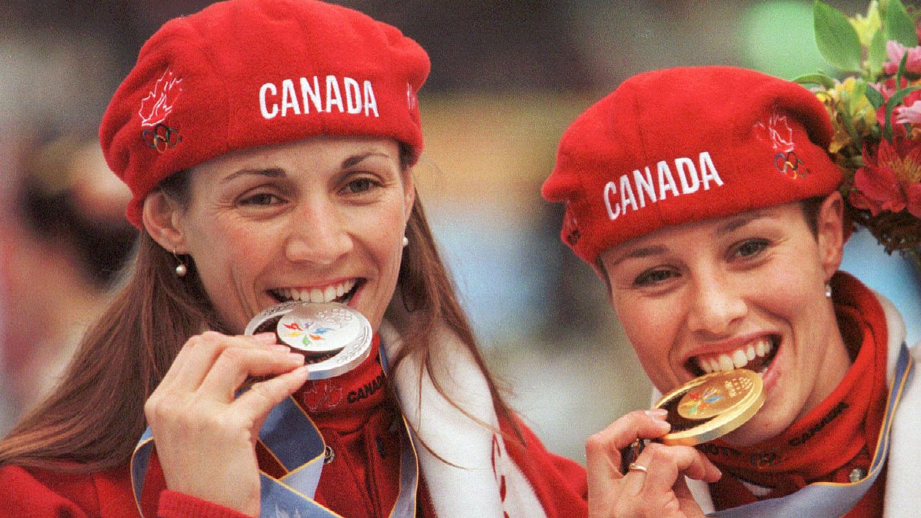 Susan Auch and Catriona Le May Doan bite their medals