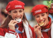 Susan Auch and Catriona Le May Doan bite their medals
