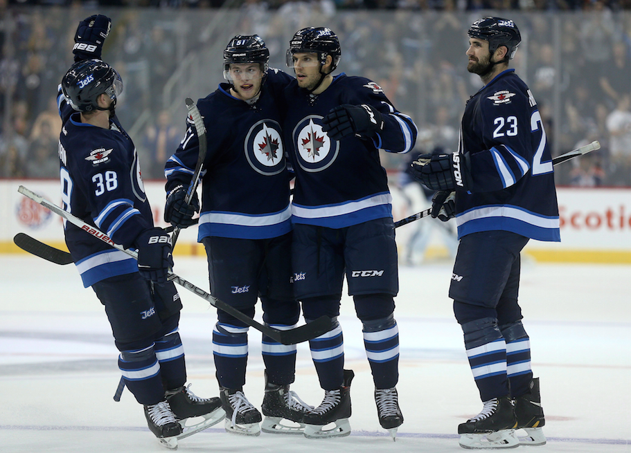 Winnipeg Jets' Nic Petan (38), Andrew Copp (51), Ben Chiarot (7) and Jay Harrison (23) celebrate after Chiarot scored against the Edmonton Oilers during second period pre-season NHL hockey action in Winnipeg, Friday, September 25, 2015.