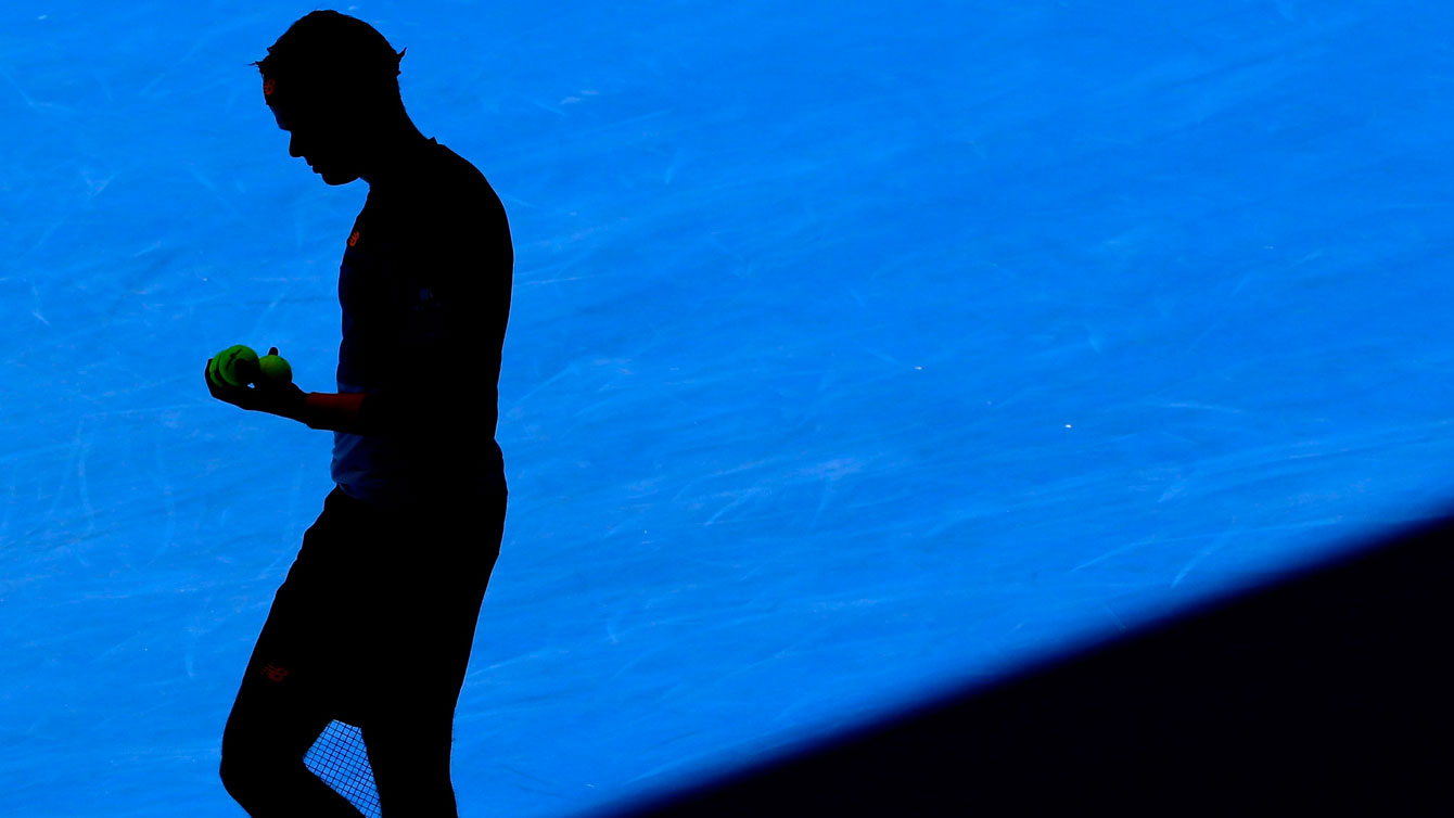The mid-afternoon sun in Melbourne puts a shadow over Milos Raonic as he prepared to serve in the Australian Open third round against Viktor Troicki on January 23, 2016. 