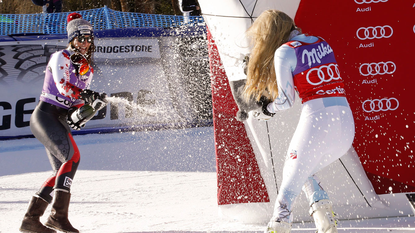 Larisa Yurkiw (left) and Lindsey Vonn spray sparkling wine given to podium finishers following the World Cup downhill race in Cortina d'Ampezzo, Italy on January 23, 2016. 