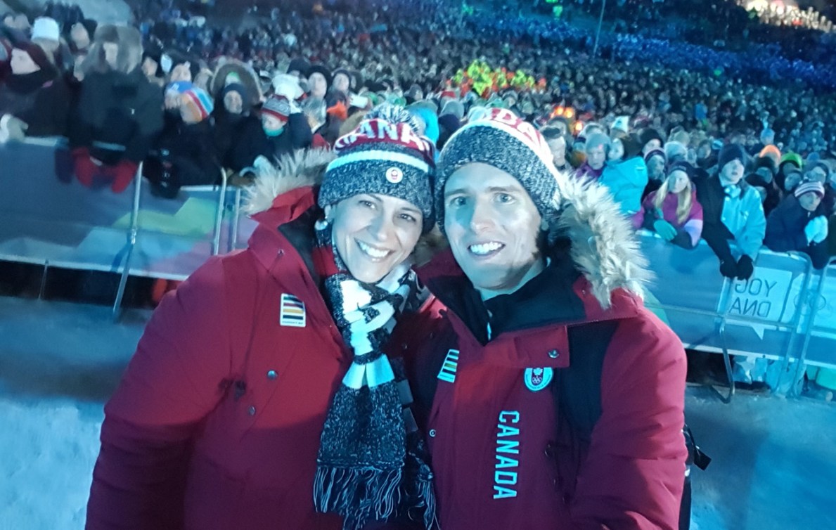 Two people dressed in Team Canada gear pose for a picture