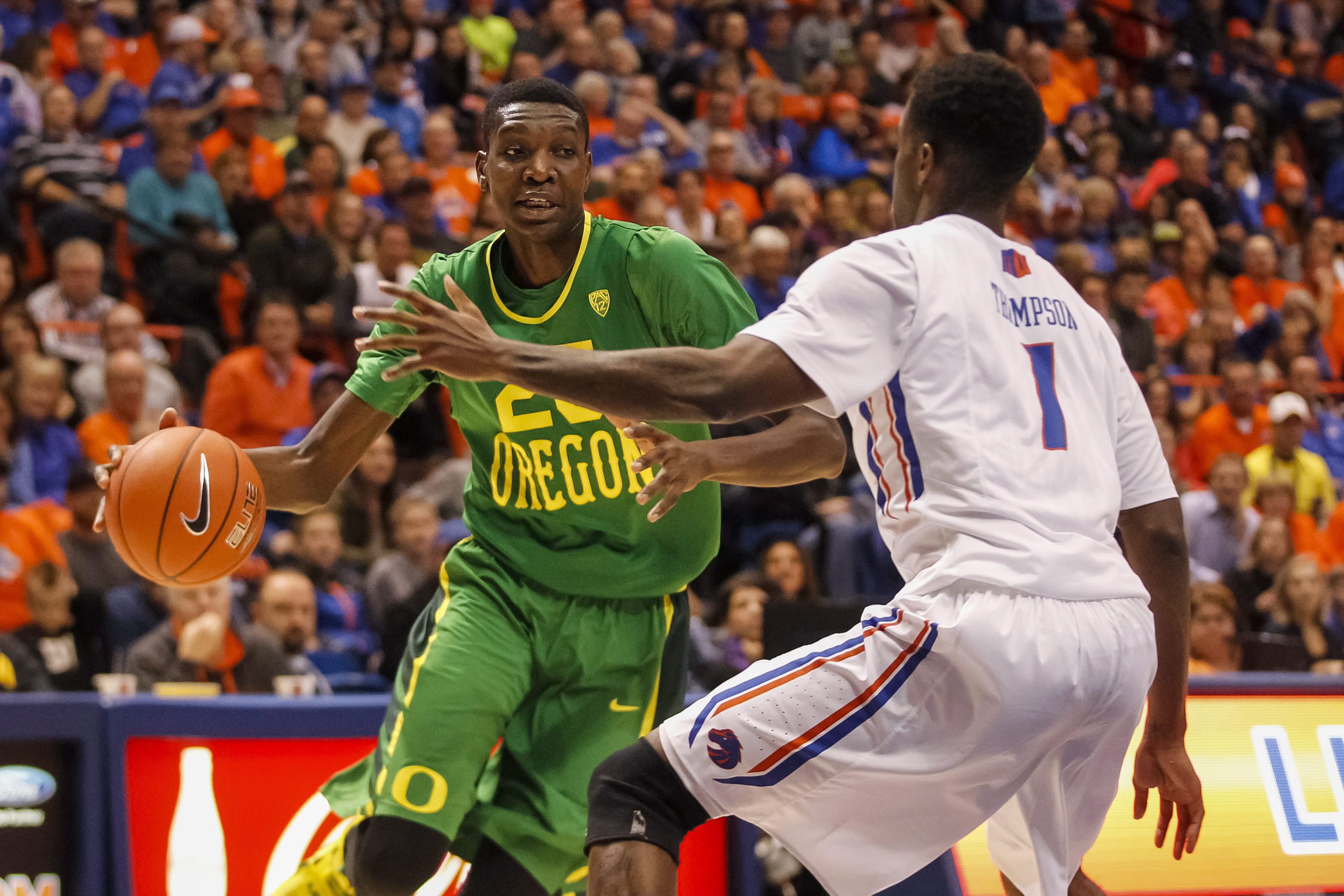 Oregon's Chris Boucher, left, moves the ball against Boise State's Mikey Thompson, right, during the first half of an NCAA college basketball game in Boise, Idaho, on Saturday, Dec. 12, 2015. (AP Photo/Otto Kitsinger)