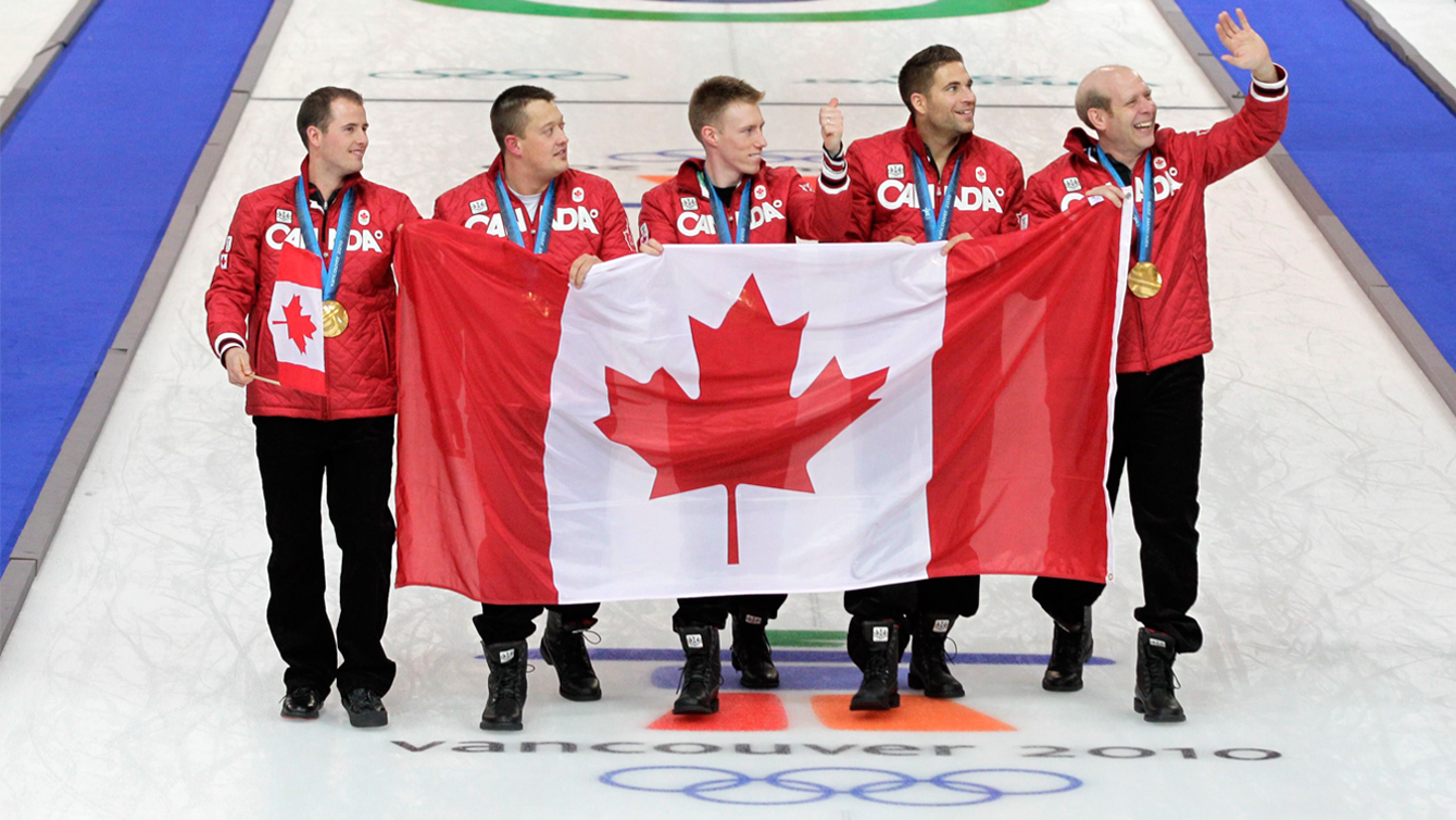 Canada's gold medalists Adam Enright, left to right, Ben Hebert, Marc Kennedy, John Morris and Kevin Martin celebrate at the men's curling medal ceremony at the Vancouver 2010 Olympics. (Photo: AP/Robert Bukaty)