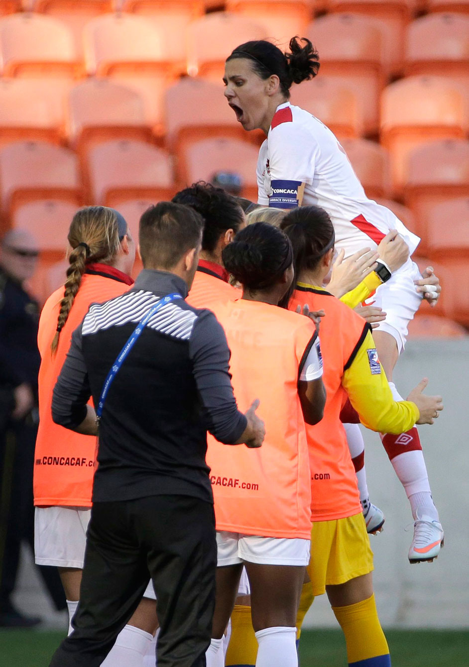 Canada's Christine Sinclair, right, leaps onto teammates as she celebrates after scoring a goal against Costa Rica during the first half of a CONCACAF Olympic women's soccer qualifying championship semifinal Friday, Feb. 19, 2016, in Houston. (AP Photo/David J. Phillip)