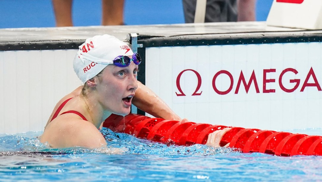 Taylor Ruck looks down the pool as she hangs onto the lane rope