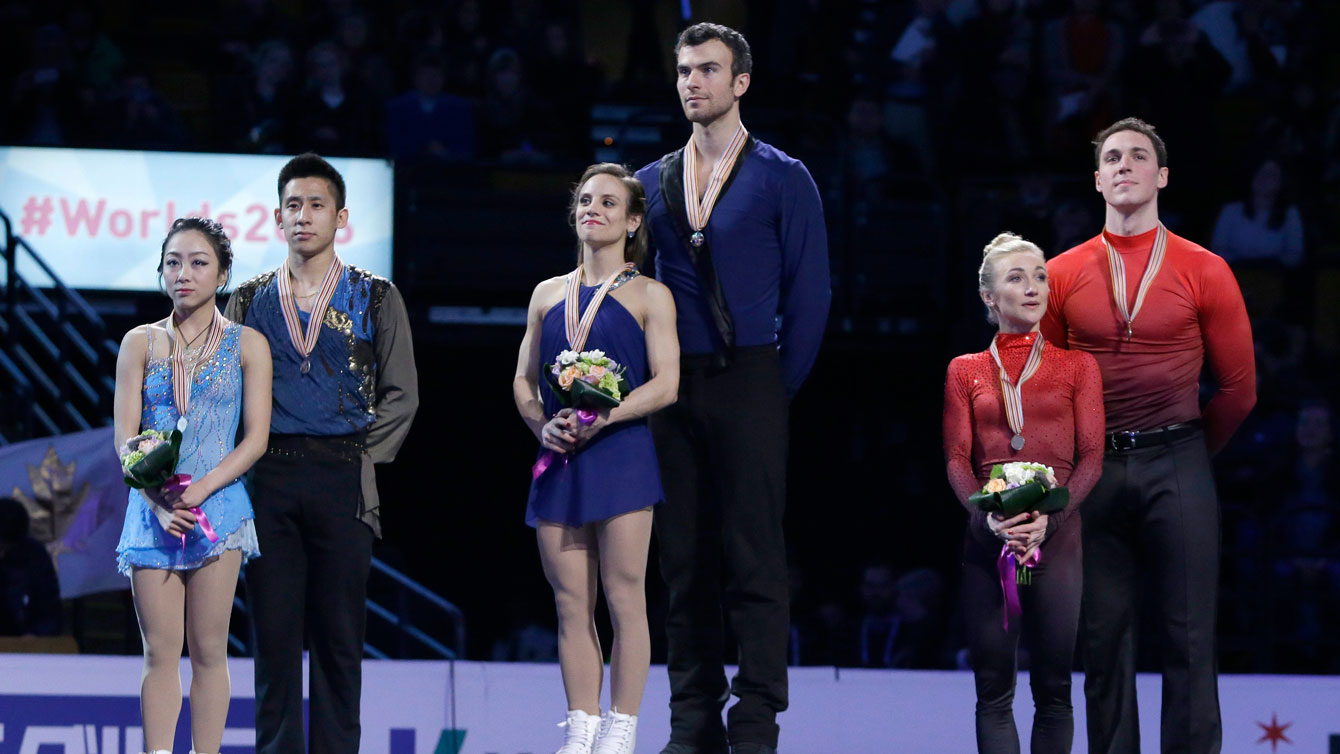 Meagan Duhamel and Eric Radford (centre) stand atop the pairs gold medal spot at the ISU Speed Skating World Championships podium ceremony on April 2, 2016. 