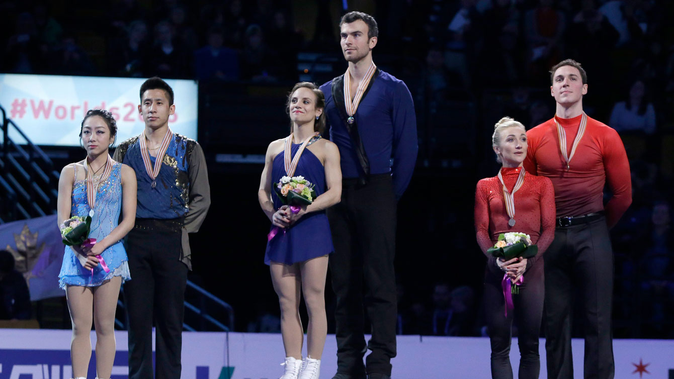 Meagan Duhamel and Eric Radford (centre) stand atop the pairs gold medal spot at the ISU Figure Skating World Championships podium ceremony on April 2, 2016. 