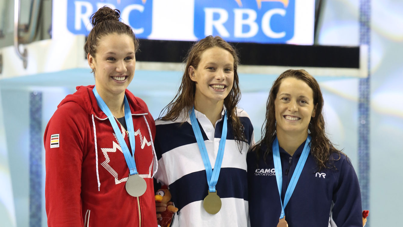 (L-R) Chantal Van Landeghem, Penny Oleksiak, Sandrine Mainville receiving their women's 100m freestyle medals from Rio Trials on April 9, 2016 (Scott Grant via Swimming Canada). 