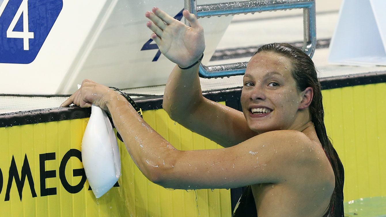 Penny Oleksiak waves after a race 