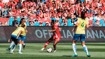 Rose controls the ball as she is surrounded by Brazilian players