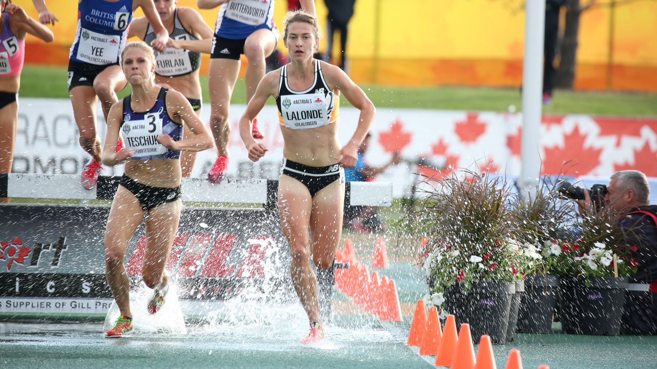 Erin Teschuk and Genevieve Lalonde clear the water hazard in the women's steeplechase at Olympic trials on June 8, 2016. Teschuk won the race, with Lalonde third.