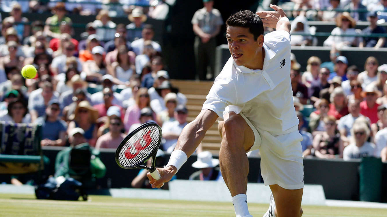 Milos Raonic reaches to connect on a backhand shot against Sam Querrey at Wimbledon quarterfinals on July 6, 2016.