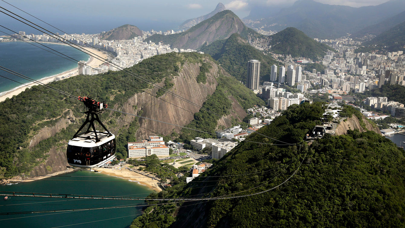 A cable car seen from the iconic Sugarloaf mountain is dwarfed by the backdrop of Rio de Janeiro, Brazil, Monday June 9, 2014.