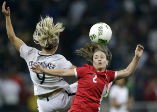 France's Eugenie Le Sommer, left, and Canada's Allysha Chapman go for a header during a quarter-final match of the women's Olympic football tournament between Canada and France in Sao Paulo, Brazil, Friday Aug. 12, 2016.(AP Photo/Nelson Antoine)