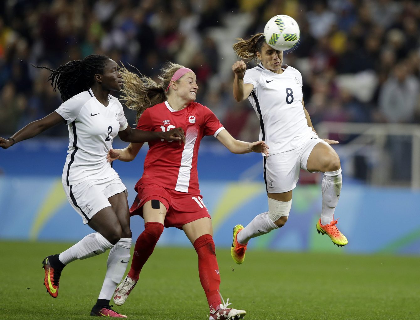 France's Jessica Houara controls the ball with her head past Canada's Janine Beckie during a quarter-final match of the women's Olympic football tournament between Canada and France in Sao Paulo, Brazil, Friday Aug. 12, 2016. At left /Canada's Allysha Chapman.(AP Photo/Nelson Antoine)