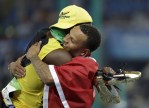 Jamaica's Usain Bolt embraces Canada's Andre De Grasse after they won gold and bronze respectively in the men's 100-meter final during the athletics competitions of the 2016 Summer Olympics at the Olympic stadium in Rio de Janeiro, Brazil, Sunday, Aug. 14, 2016. (AP Photo/David Goldman)