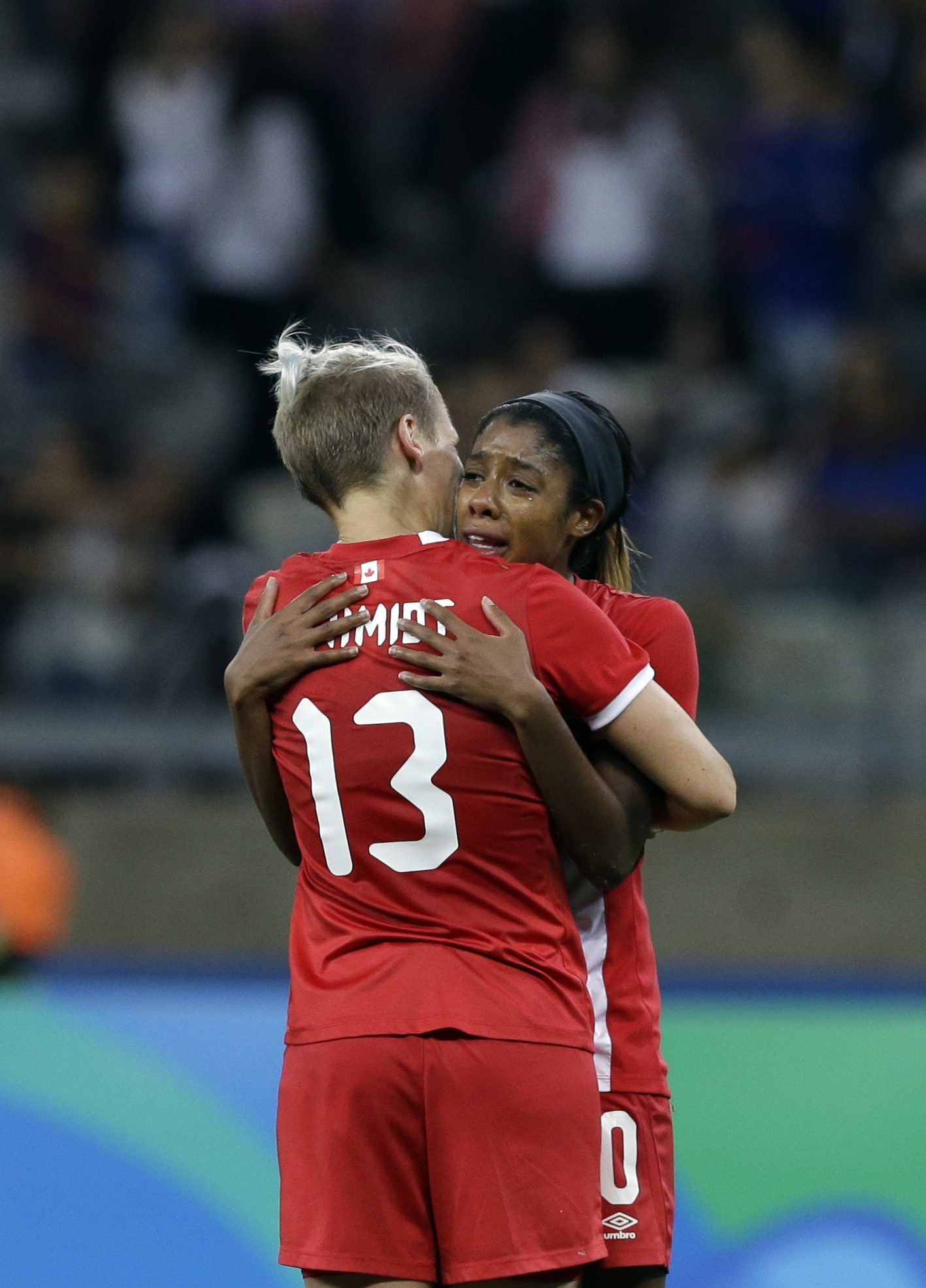 Canada's Sophie Schmidt, 13, and Ashley Lawrence comfort each other after a semifinal of the women's Olympic football tournament between Germany and Canada at the Mineirao Stadium in Belo Horizonte, Brazil, Tuesday, Aug. 16, 2016. Germany beat Canada 2-0 to reach the final against Sweden.(AP Photo/Leo Correa)