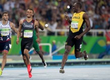 Bolt and De Grasse smiling as they cross the finish line