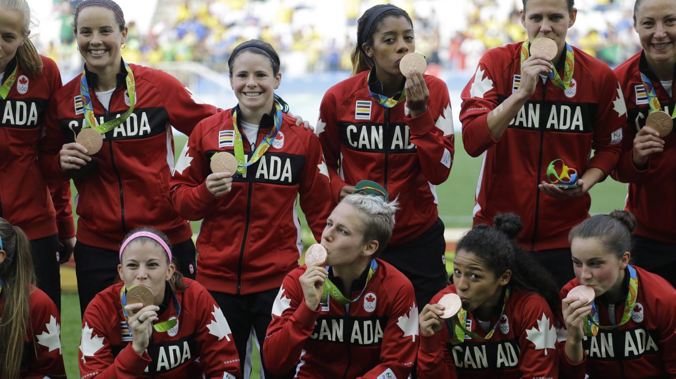 Canada team poses for photos after winning the bronze medal in the women's Olympic football tournament between Brazil and Canada at the Arena Corinthians stadium in Sao Paulo, Friday Aug. 19, 2016. (AP Photo/Nelson Antoine)