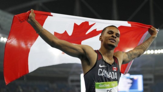 Rio 2016: De Grasse 200m Canada's Andre De Grasse celebrates with his nation's flag after earning a silver medal in the men's 200m final in Rio on August 18, 2016. (photo/ Stephen Hosier)