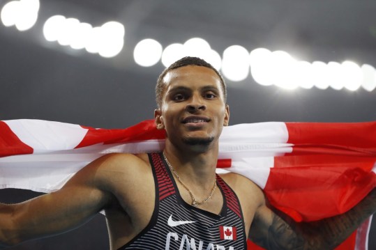 Rio 2016: De Grasse 200m Canada's Andre De Grasse celebrates with his nation's flag after earning a silver medal in the men's 200m final in Rio on August 18, 2016. (photo/ Stephen Hosier)