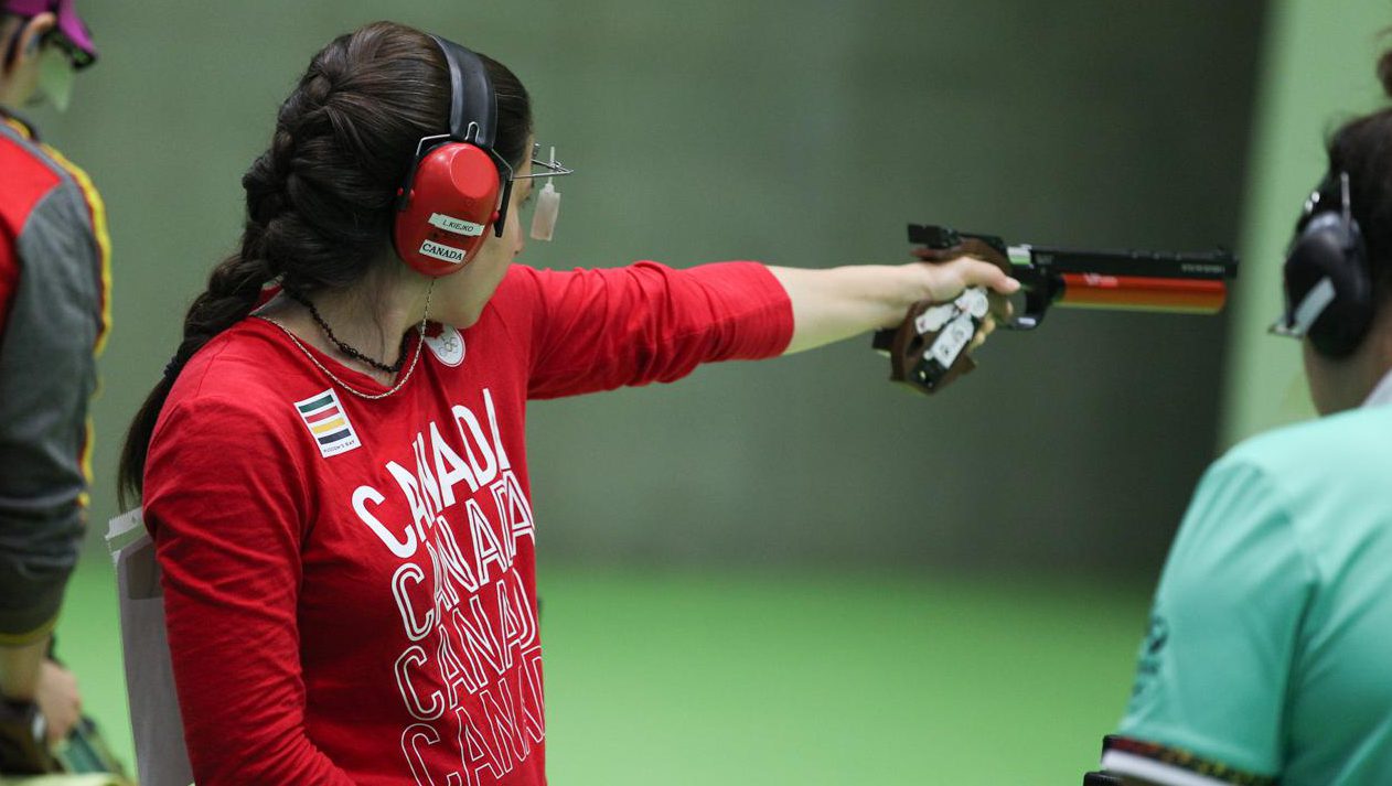 Lynda Kiejko holds her pistol at arms length to shoot