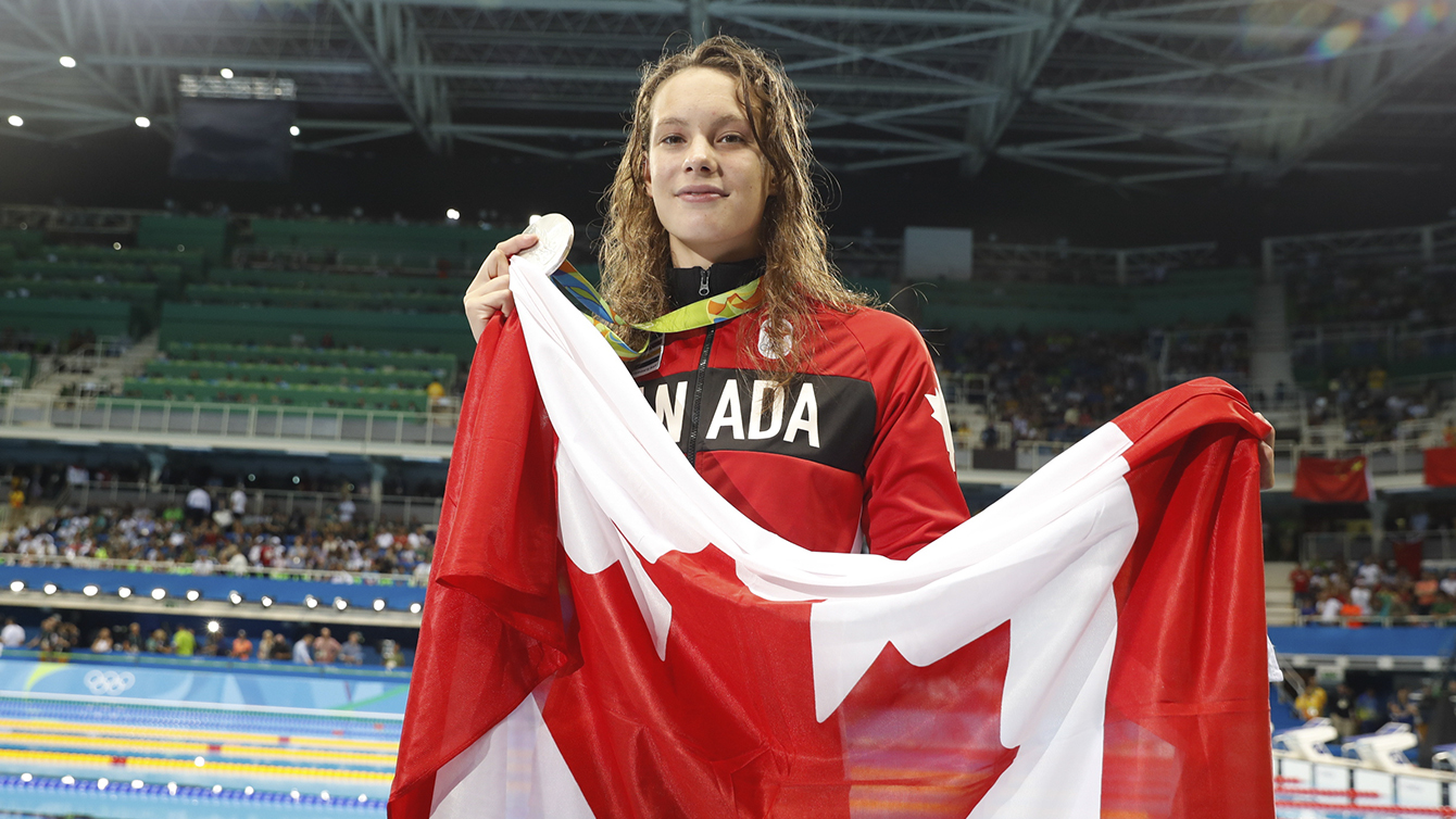 Penny Oleksiak holds the flag after winning silver in the 100m butterfly on August 7, 2016 during Rio 2016.