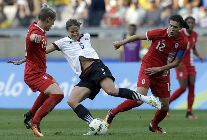 Germany's Annike Krahn controls the ball next to Canada's Sophie Schmidt, left, and Christine Sinclair during a semifinal match of the women's Olympic football tournament between Germany and Canada at the Mineirao Stadium in Belo Horizonte, Brazil, Tuesday, Aug. 16, 2016. (AP Photo/Leo Correa)