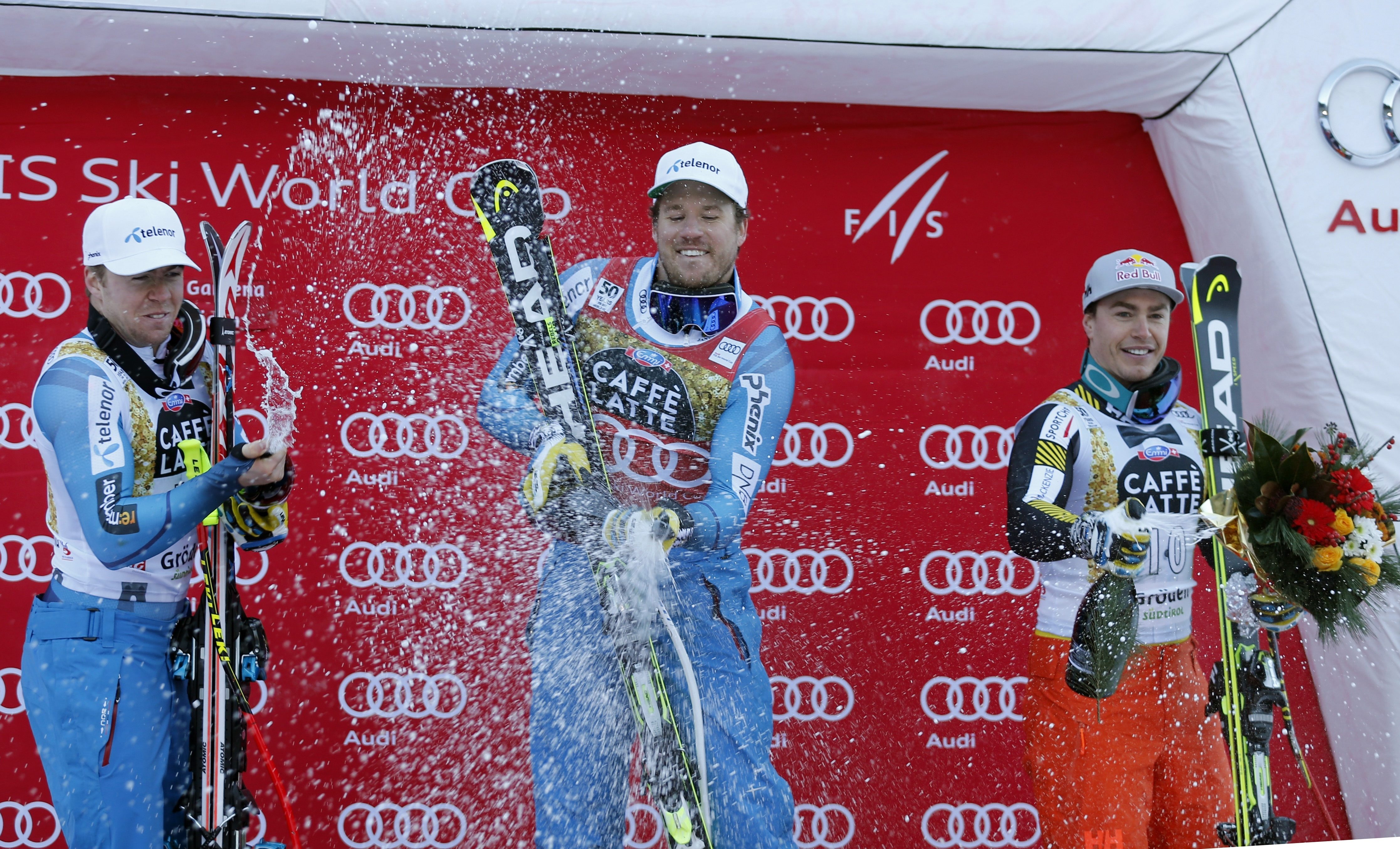 Norway's Kjetil Jansrud, center, winner of an alpine ski, men's World Cup super-G, celebrates on the podium with second placed Norway's Aleksander Aamodt Kilde, left, and third placed Canada's Erik Guay, in Val Gardena, Italy, Friday, Dec. 16, 2016. (AP Photo/Marco Trovati)