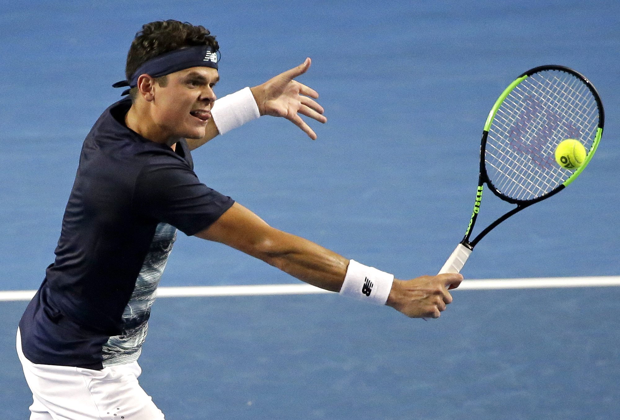 Canada's Milos Raonic makes a backhand return to France's Gilles Simon during their third round match at the Australian Open tennis championships in Melbourne, Australia, Saturday, Jan. 21, 2017. (AP Photo/Dita Alangkara)