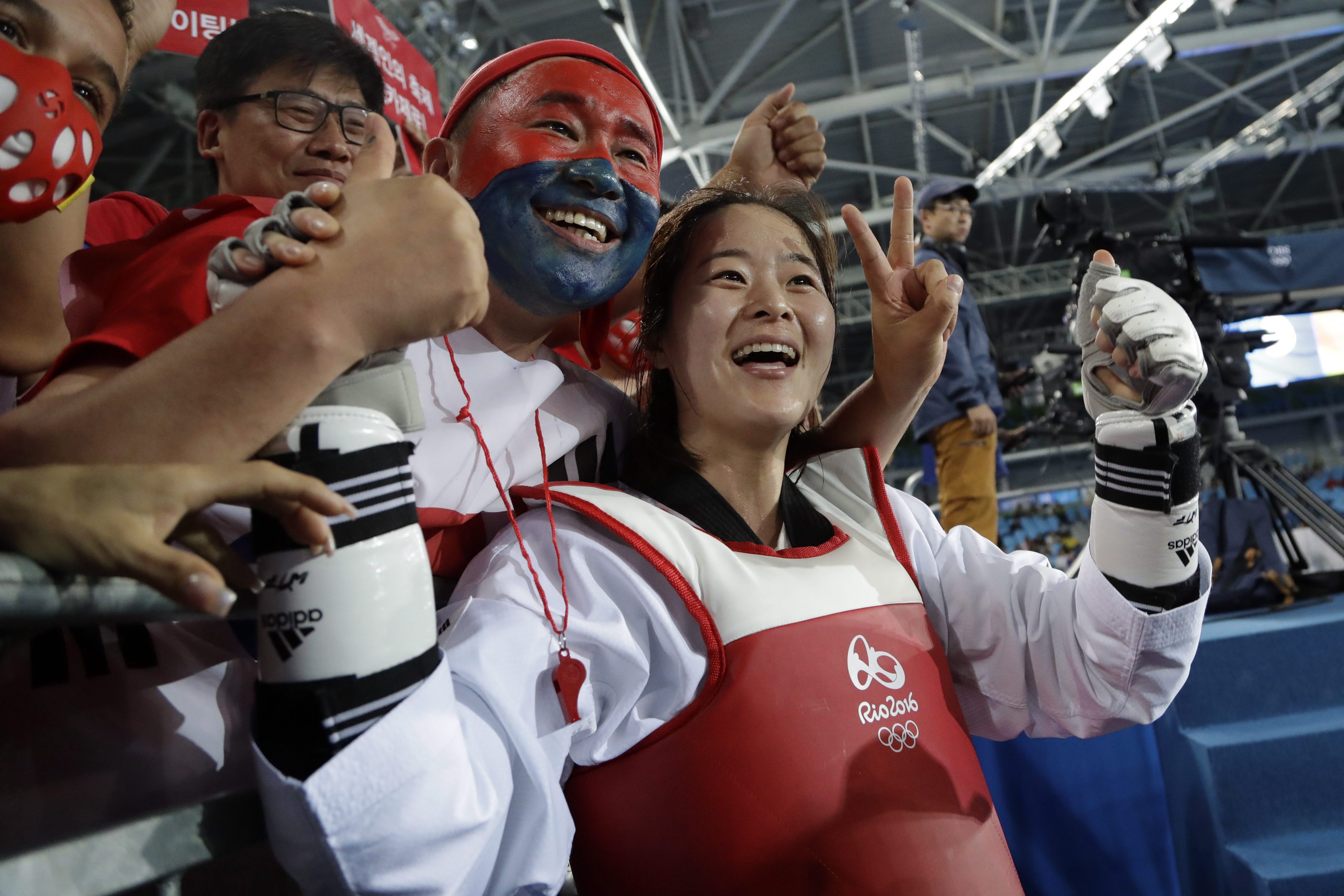 Oh Hye-ri of South Korea celebrates with fans after winning the gold medal in the women's 67 kg taekwondo competition at the 2016 Summer Olympics in Rio de Janeiro, Brazil, Friday, Aug. 19, 2016. (AP Photo/Gregory Bull)