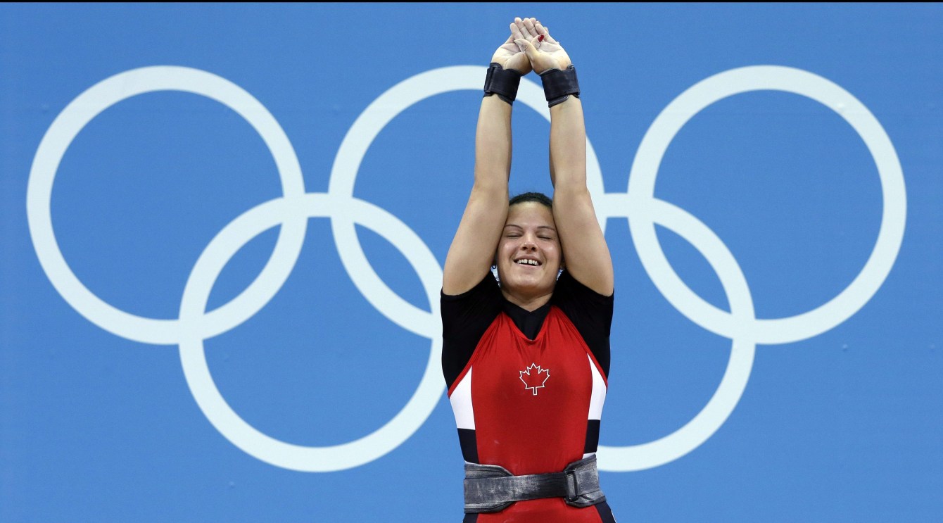 Christine Girard stretches her arms to the sky in celebration 