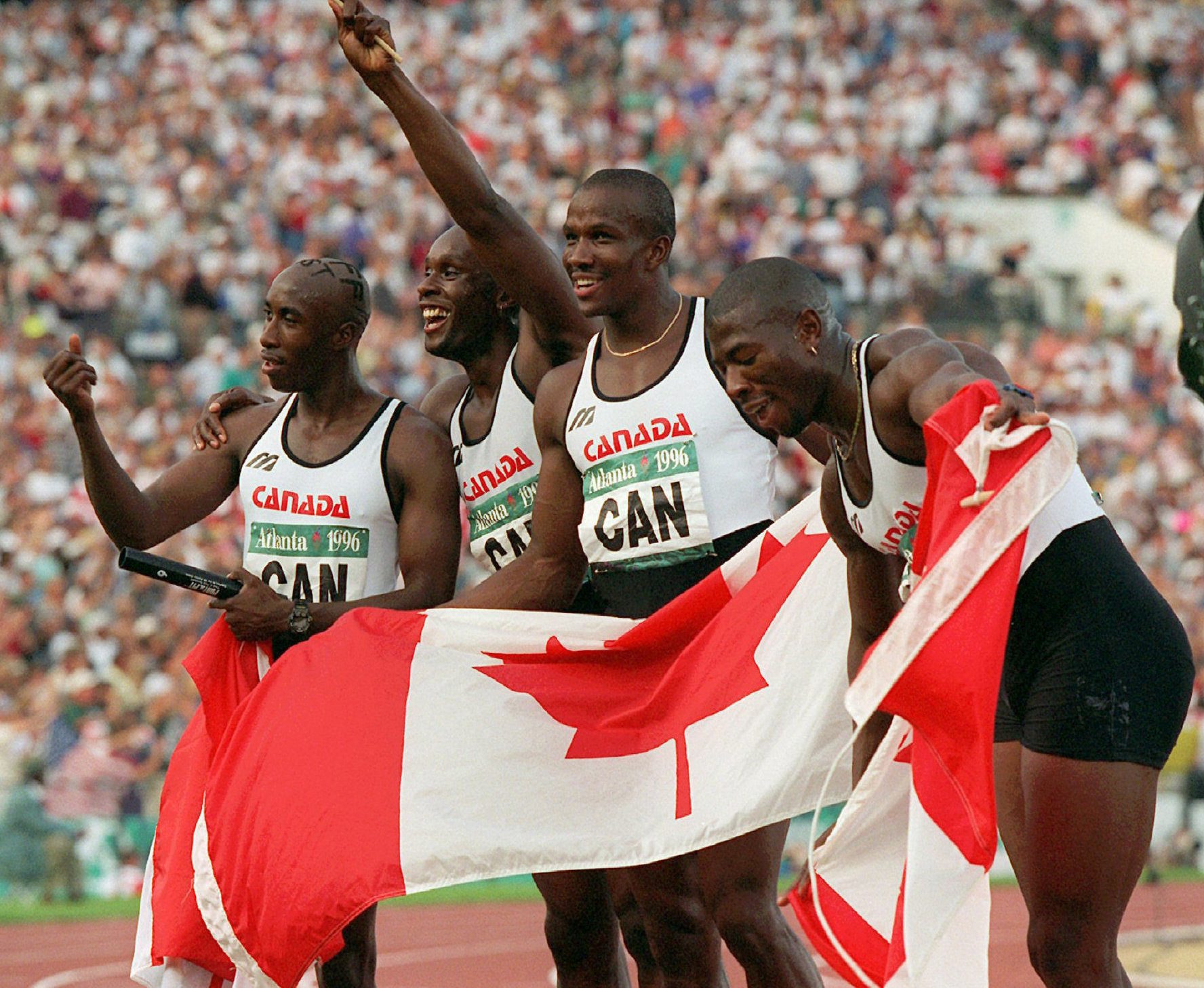 The Canadian men's 4X100 metre relay team celebrate after winning the gold medal at the Summer Olympic Games in Atlanta, Saturday, August 3, 1996. Seen from left to right are Robert Esmie, Bruny Surin, Donovan Bailey and Glenroy Gilbert. (AP Photo/DenisPaquin)